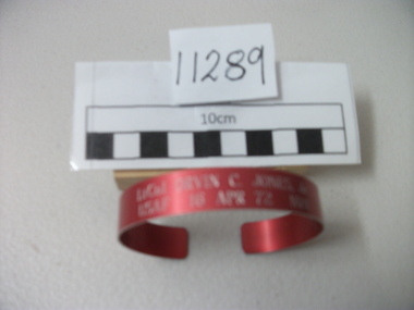 Red coloured aluminium MIA USAF bracelet.