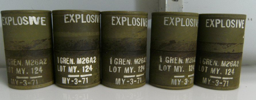 Five Green Metal Cannisters with EXPLOSIVE Written in White on the Top