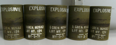 Five Green Metal Cannisters with EXPLOSIVE Written in White on the Top