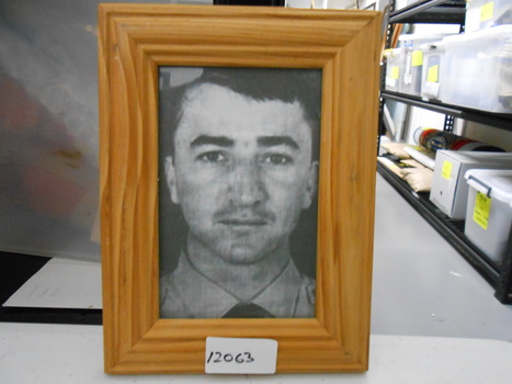 Framed black and white head and shoulders photo of P.O. Carver (Missing In Action) in dress shirt