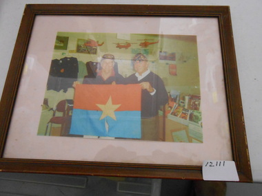 Coloured photo of John Methven (founder of the museum) and a visiting Vietnam veteran. 