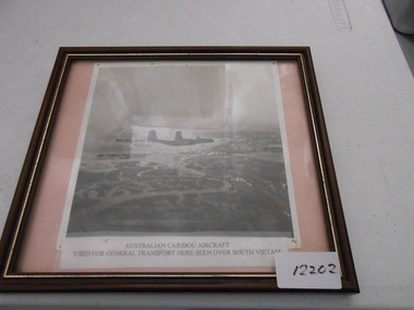 A black and white photo on cardboard of two Australian Caribou aircraft.