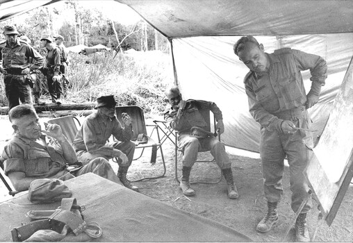 A photograph of Gen. Creighton Abrams, Brig Sandy Pearson & Maj Gen A.L MaAudio, C.Donald receive a briefing from Lt Col A.L. Morrison. 