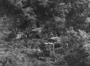 A photograph of a D8 bulldozer 'Miss Fit' involved in land and mine clearing operations up to the foothills of the Long Hai Mountains. 