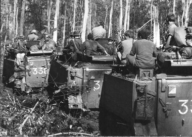 A photograph of APCs fully loaded with diggers of 3 Troop, 3 Sqn are held up in heavily timberd country in Phuoc Tuy Province. 