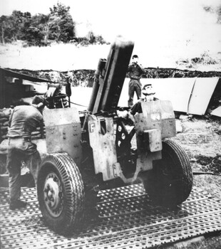 A black and white photograph of Gunners firing on NVA Sappers at Long Bien 