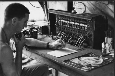 A photograph of Pte Jack Higgins, mannibg the A Coy 7 RAR telephone exchange at 1 ATF Base Nui Dat