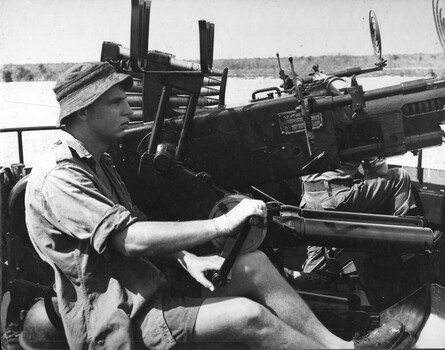 A black and white photograph of Engineer crew of Landing  Craft Vernon Sturdie man a Bofors Gun on the Mekong River. 