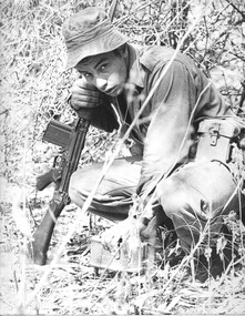 A black and white photograph of an NZ infantry soldier Pte Growden a member of 4 RAR/NZ sets up a claymore mine ambush.