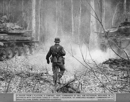 A photograph of a digger from 2 Platoon, A Coy 1 RAR advances with Centurian tanks of 1 Troop, C Squadron, 1st Armoured Regiment. 