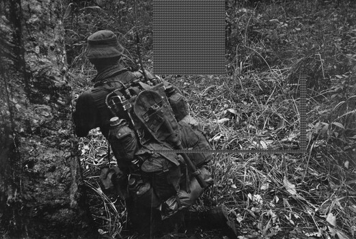 A photograph of  Pte Graeme C Piltz goes to ground under fire from heavy machine gun, automatic weapon, rifle and RPG fire