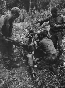 Diggers from A Coy, 8 RAR fix one of their wounded mates to be winched out of the jungle for transport to Hospital.