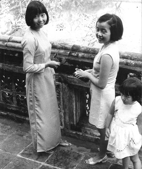 A photograph of the three daughters of the Province Chief at Hue enjoy the afternoon breeze on the balcony of their Father's house. 