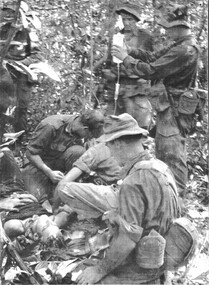  A wounded 1 RAR digger is treated by Dr Maj Mike Naughton prior to being airlifted an a Dustoff helicopter. 