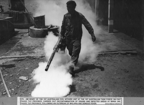 A photograph of Cpl Jim Henry of the 1st Australian Civil Affairs Unit, Nui Dat, carries out decontamination of drains Baria Jail.