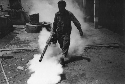 A photograph of Cpl Jim Henry of the 1st Australian Civil Affairs Unit, Nui Dat, carries out decontamination of drains Baria Jail.