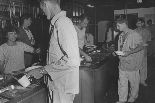 A photograph at st Australian Field Hospital, ambulatory patients from the hospital wards, pass through the kitchen servery to collect their evening meal.