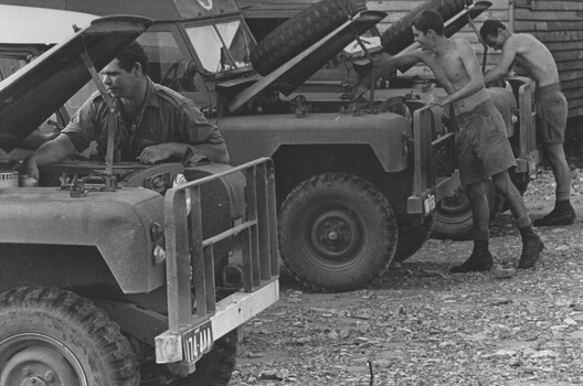 A photograph at 1st Australian Field Hospital, Diggers responsible for transport carry out daily maintenance on the fleet of hospital ambulances. 