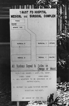 A black and white photograph of -  At the 1st Australian Field Hospital a sign shows layout of the hospital complex and local orders.