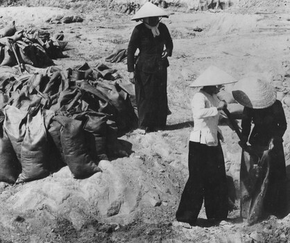 Vietnamese women from local villages and the Phuoc Tuy Province, Baria fill sandbags to be used at the 1 Australian Task Force (1ATF) Base.  