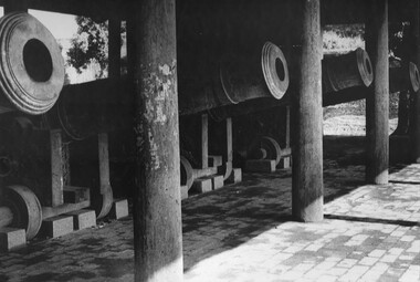 A photograph of a part of a battery of large cannon sit in their bay at the Imperial Palace Hue, South Vietnam. 