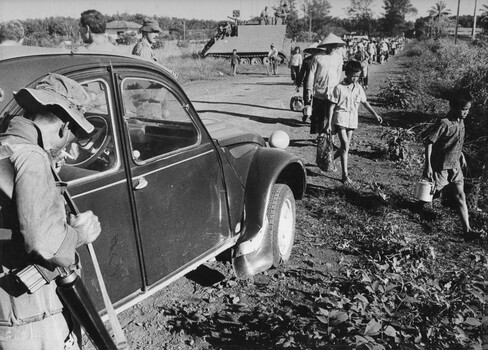 A photograph of a 5 RAR digger, guards the Binh Ha plantation owners car, while a command armoured personnel carrier parks nearby. 