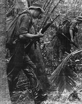 Pte Jack Higgins batman to the Company Commander Maj Jake O'Donnell  MC Headquarters, 7 RAR  moves through thick jungle in the rain. 