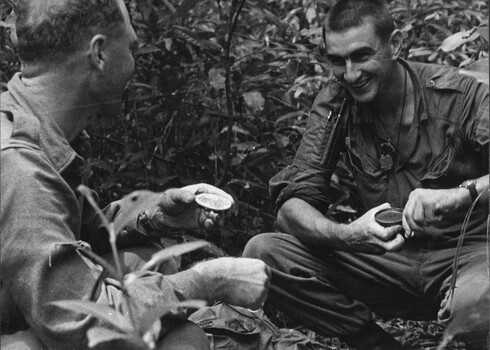 A  photo of Pte Jack Higgins opening a can, enjoys a joke with his boss Maj Jake O'Donnell MC, A Coy, 7 RAR. 