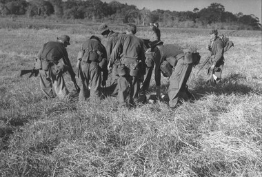 Diggers from 11 Platoon, D Coy, 6 RAR on Operation Portsea gently place their Pte Ken Mathieson on the ground waiting for a Dustoff helicopter.