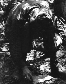 A photograph of a digger 'Vietnamese Linguist' attached to 1st Australian Task Force, NVA/VietCong documents captured during a battle in the Hat Dich area. 