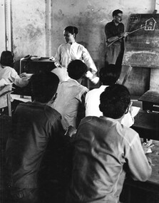 A Vietnamese Linguist from 1st Australian Civil Affairs Unit at the 1st Australian Task Force Base, condusts a mixed adult English class for Vietnamese  adults.