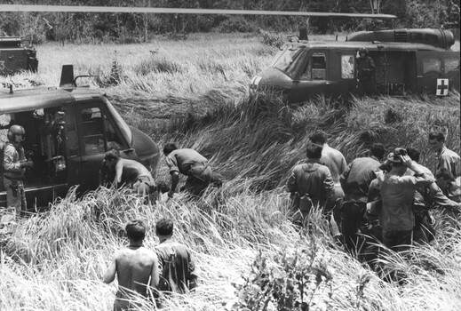 A photograph of an RAAF "slick: helicopter, from 9 Squadron loads wounded Diggers following the destruction of an APC 13A during Operation Massey Harris. 