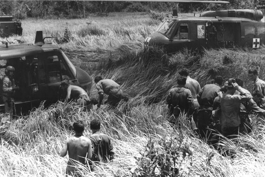 A photograph of a RAAF "slick" helicopter from 9 Sqadron loads wounded Diggers following the destruction of APC 13A during Operation Massey Harris.