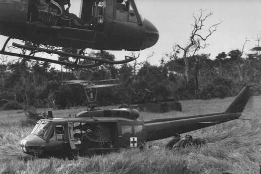 A RAAF "slick" helicopter from 9 Squadron, flies past a U.S. "dustoff" helicopter with a load of wounded Diggers. 