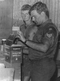 Two Diggers of the 1st Australian Field Hospital, Stores Section check the quality of requisitioned stores in the form of plaster of paris bandages. 