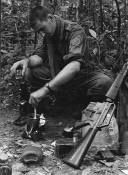 Pte Jack Higgin, Chelsea, Victoria brews a coffee for himself and his boss Maj Jake O'Donnell MC, A Coy, 7 RAR  during Operation Caroline.