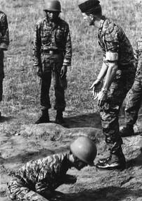 Bearcat South Vietnam, a member of Australian Army Ttraining Team Vietnam instructs Vietnamese Ranger recruits in the correct way to land during parachute training