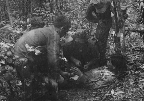 A Medic Digger of 11 Platoon, D Coy 6 RAR/NZ (ANZAC) gives a wounded NVA/VietCong treatment, following a very successful ambush during Operation Lavarack. 