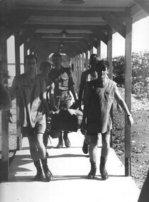 Medic Glen Edwards (author of The War Within) helps his fellow medics transport a wounded digger from Vampire helicopter. 