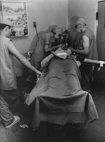 Sister June Minchow assists the anaesthetists while medic John Tulloch looks on in preparing a badly burned American helicopter pilot for surgery. 