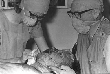 Theatre Sister June Minchow, in the operating theatre, prepares an American pilot badly burned when is helicopter was shot down, for surgery. 