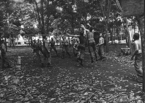 Diggers at the 1st Australian Task Force Base enjoy a spirited game of net ball under the rubber trees.