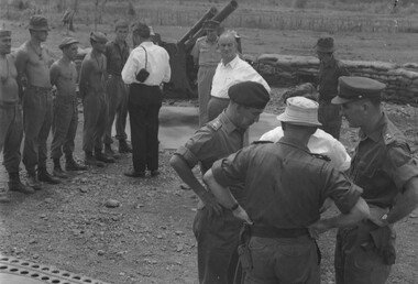 At 1 ATF Base Nui Dat while one of the visiting politicians from New Zealand talks with a gun detachment at 161 Battery RNZA,