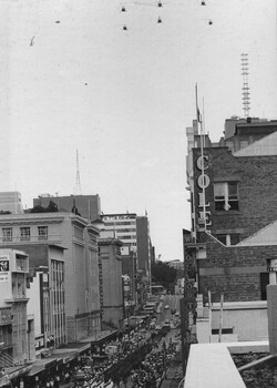 Diggers of 8th Battalion, RAR march through the City of Brisbane through a paper streamer welcome, past the City Hall, while Sioux Helicopters fly overhead