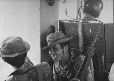 Two South Vietnamese rangers sharing a joke as they are lifted into an operation by the 135th Assault Helicopter Company.  