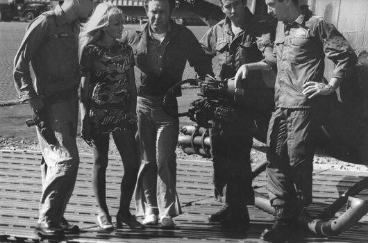 During a lunch break at the RAAF Base at Vung Tau, Johnny O'Keefe and a female singer visit a crew at No. 9 Suadron's "Bushranger".