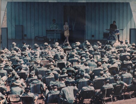 Lead singer of the Official Jun 69 Tasmanian Concert Party is dwarfed by the Diggers packed right up to the edge of the stage. 