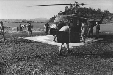 Medics and Intelligence Officers rush to meet and unload an American Dustoff medical evacuation helicopter bringing wounded NVA/Viet Cong.