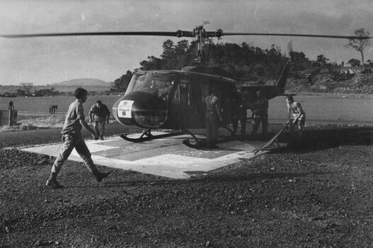 Medics and Intelligence Officers rush to meet and unload a second American Dustoff medical evacuation helicopter bringing wounded NVA/Viet Cong.