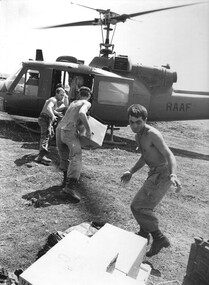 Gunner Doug Blenkiron tosses cases of US Army C-Rations to Gunner Doug (name unreadable) at 1 ATF Base Nui Dat. 